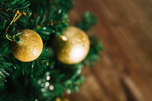 Twee gouden kerstballen op kerstboom