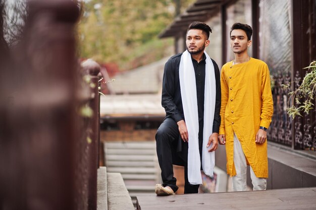 Twee Indiase stijlvolle mans vrienden in traditionele kleding poseerden buiten