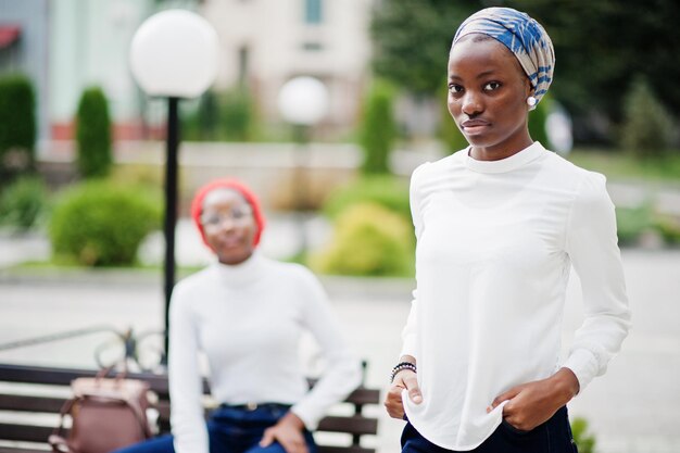 Twee jonge, moderne, modieuze, aantrekkelijke lange en slanke Afrikaanse moslimvrouwen in hijab of tulbandhoofddoek poseerden samen