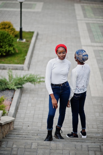 Twee jonge, moderne, modieuze, aantrekkelijke lange en slanke afrikaanse moslimvrouwen in hijab of tulbandhoofddoek poseerden samen