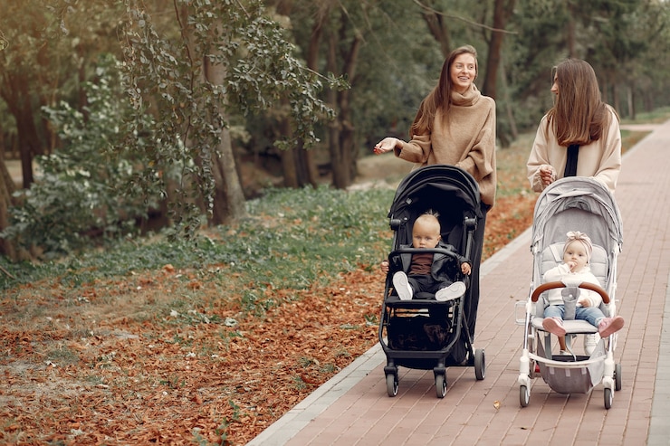 Gratis Foto twee jonge moeders lopen in een herfst park met rijtuigen