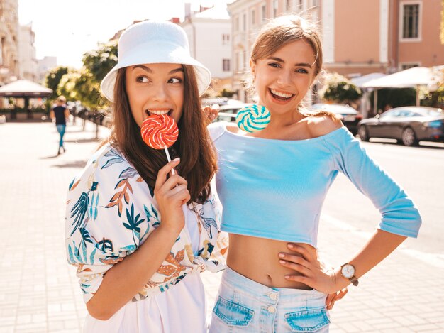 Twee jonge mooie glimlachende hipster meisjes in trendy zomer kleding en panama hoed.