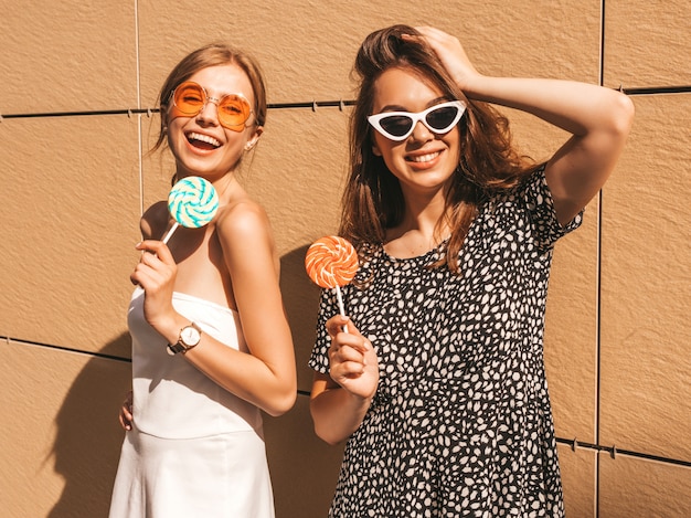 Twee jonge mooie glimlachende hipster meisjes in trendy zomerjurk.