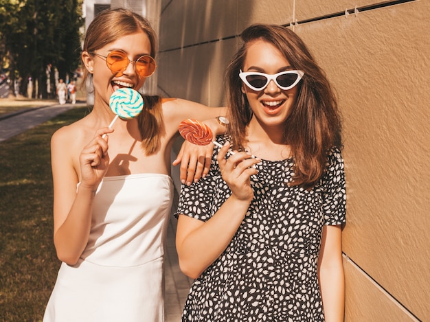 Twee jonge mooie glimlachende hipster meisjes in trendy zomerjurk.