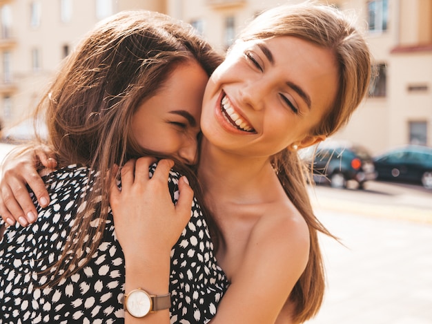 Twee jonge mooie glimlachende hipster meisjes in trendy zomerkleren