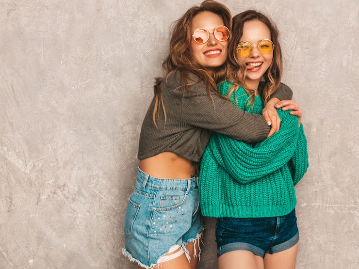 Gratis Foto twee jonge mooie lachende prachtige meisjes in trendy zomerkleren. sexy zorgeloze vrouwen poseren. positieve modellen met plezier in ronde zonnebril