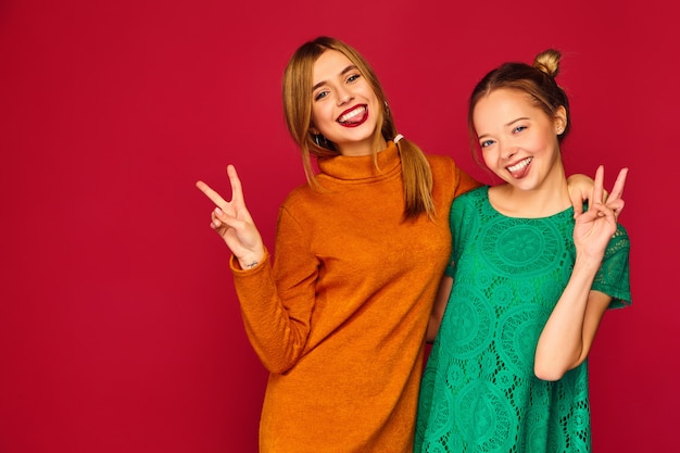 Twee jonge mooie vrouwen die zich in trendy kleding stellen