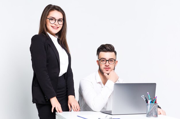 Twee jonge succesvolle mensen met laptop op witte muur