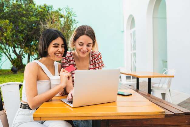 Twee jonge vrienden die online winkelen.