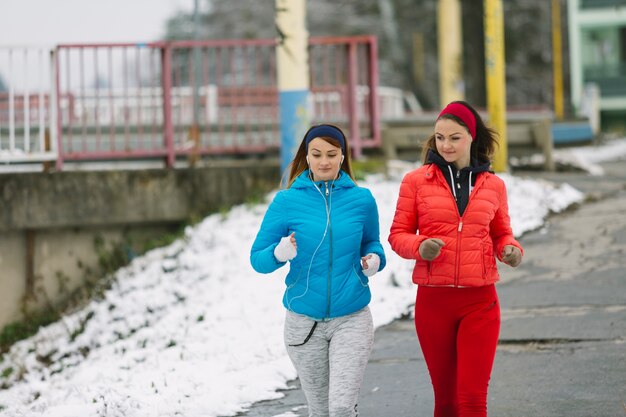 Twee jonge vrouwen die op straat in de winter lopen