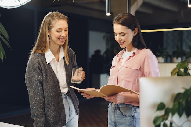 Twee jonge vrouwen werken samen op kantoor