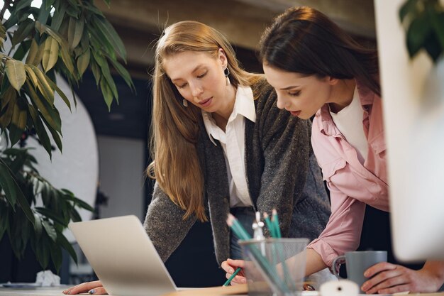 Twee jonge vrouwen werken samen op kantoor