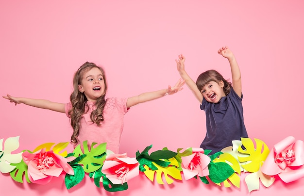 Gratis foto twee kleine meisjes op zomer roze muur
