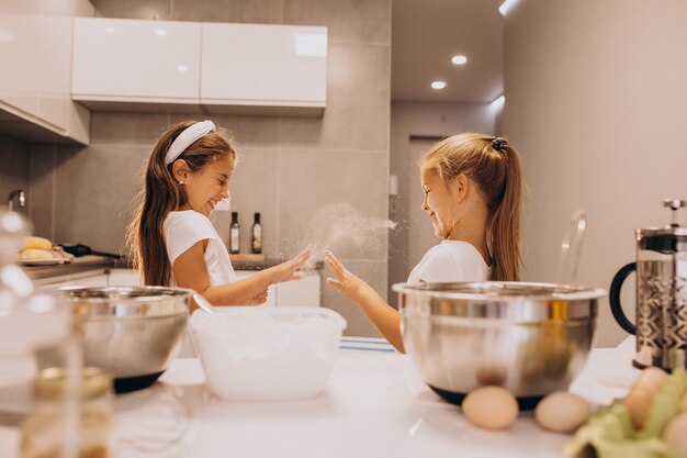 Twee kleine meisjes zusjes koken in de keuken