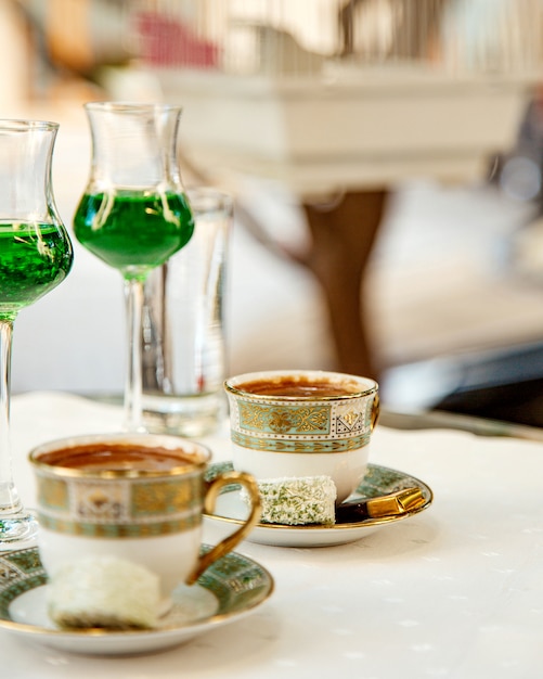 Twee kopjes turkse koffie geserveerd met snoep