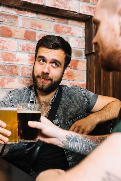 Twee mannelijke vrienden die alcoholische dranken roosteren