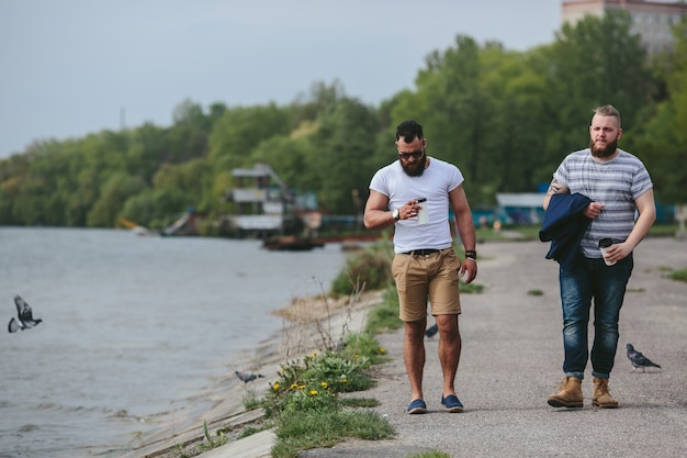 Twee mannen lopen en drinken koffie