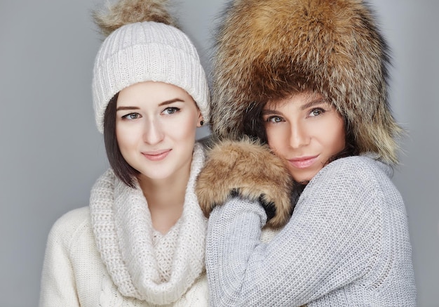 Twee meisje in winterkleren selfie foto's maken op smartphone. Gratis Foto