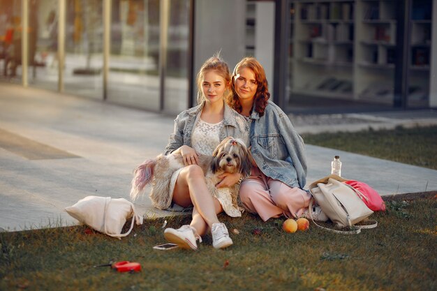 Twee meisjes die in een park met een kleine hond wallking