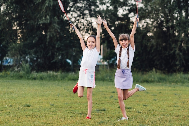 Twee meisjes die in het badminton van de parkholding genieten van
