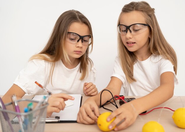 Twee meisjes die wetenschappelijke experimenten met citroenen doen