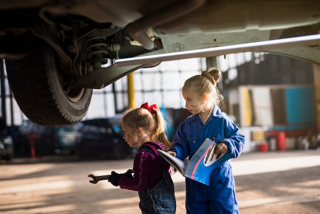 Twee meisjes in overall staan met roet en magazine