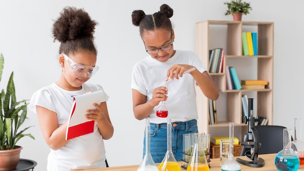 Twee meisjes met een veiligheidsbril met scheikundige experimenten