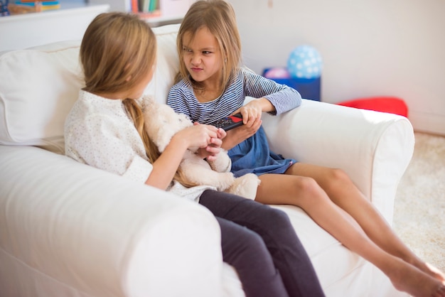 Twee meisjes ruzie maken over de afstandsbediening