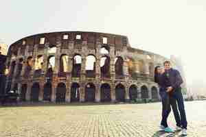 Gratis foto twee mensen staan ​​in de buurt van het colosseum in rome