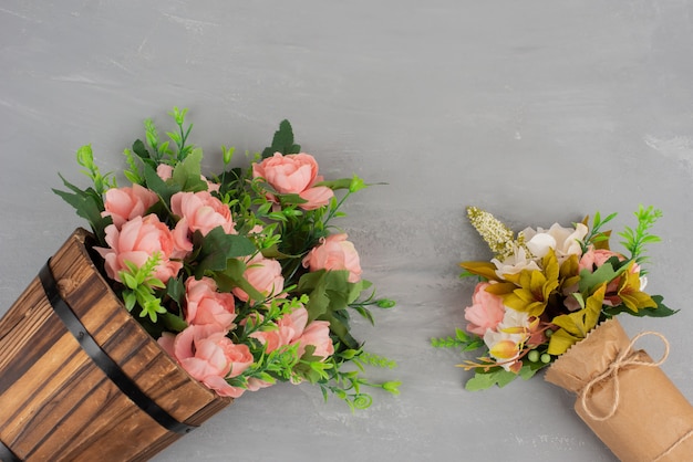 Twee mooie boeketten bloemen op grijze ondergrond.