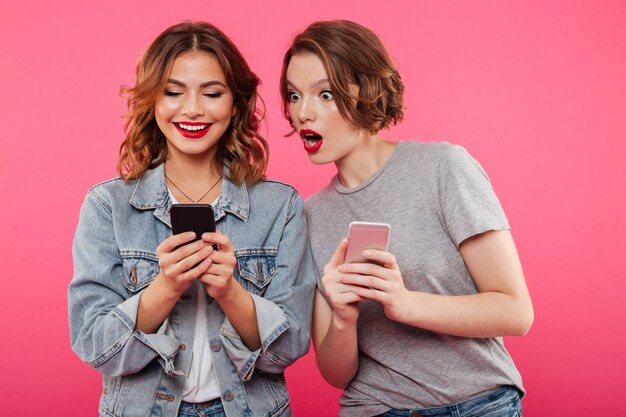 Twee mooie damesvrienden die telefonisch babbelen.