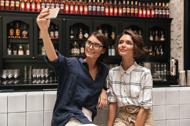 Twee mooie glimlachende vrouwen maken selfie