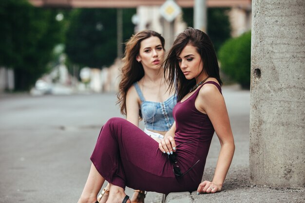 Twee mooie jonge meisjes poseren op straat