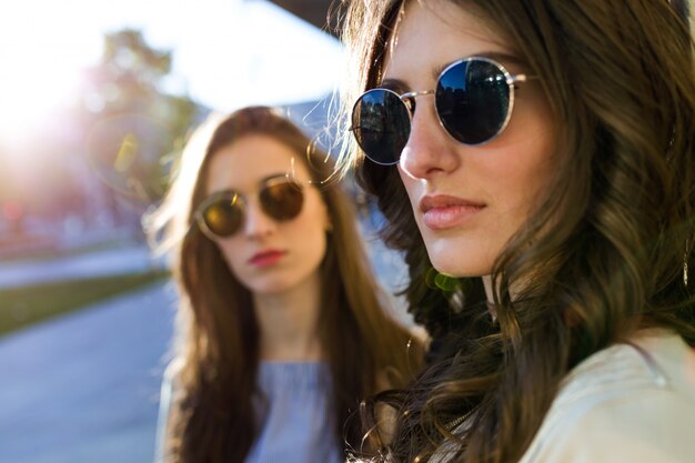 Twee mooie jonge vrouwen poseren in de straat.