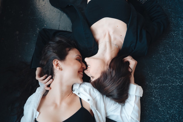Twee mooie meisjes liggen op de vloer