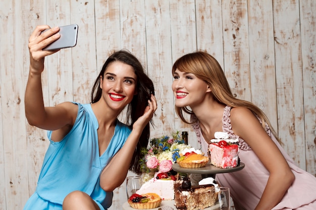 Twee mooie meisjes maken selfie op feestje.