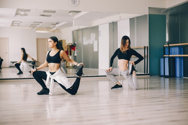 twee mooie slanke meisjes doen dansen en gymnastiek in de dance hall