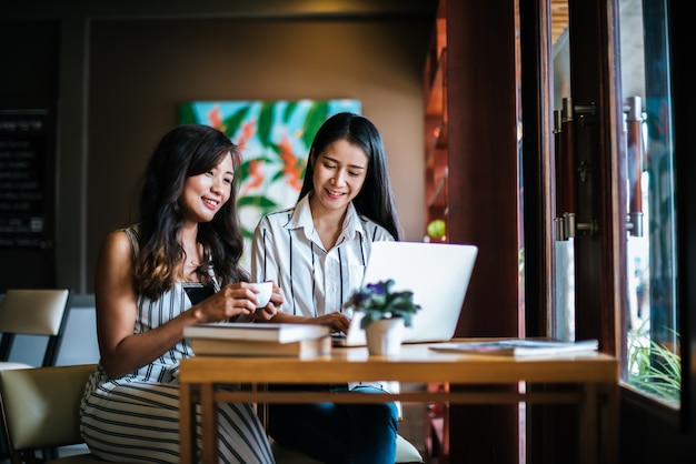 Twee mooie vrouwen die alles samen spreken bij de koffie van de koffiewinkel