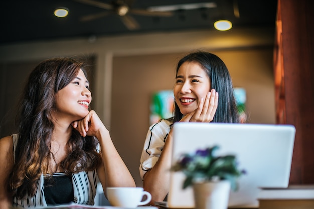 Twee mooie vrouwen die alles samen spreken bij de koffie van de koffiewinkel