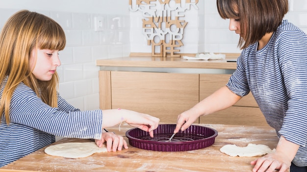 Twee mooie zusters die in keuken koken