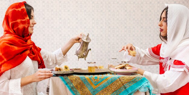 Twee moslimvrouwen die aan tafel zitten