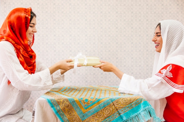 Twee moslimvrouwen die aan tafel zitten