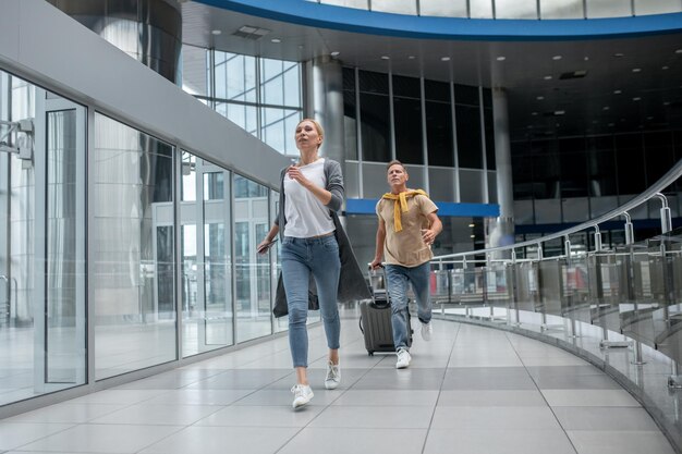 Twee opgewonden passagiers haasten zich door de luchthaventerminal