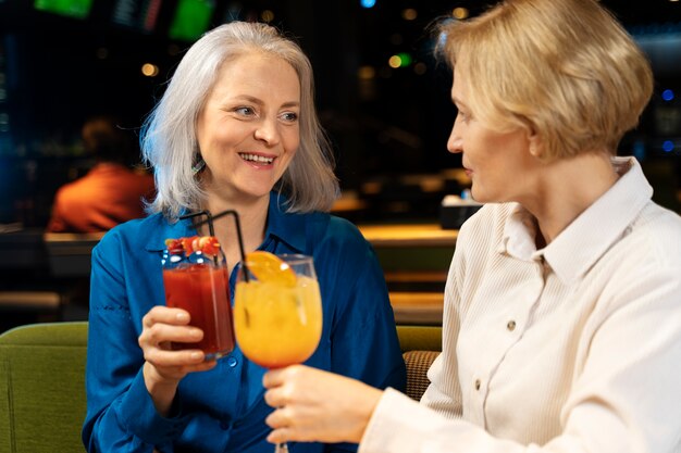 Twee oudere vriendinnen drinken in een restaurant