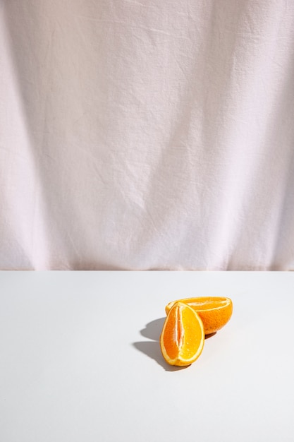 Twee plakjes sinaasappelen op wit bureau