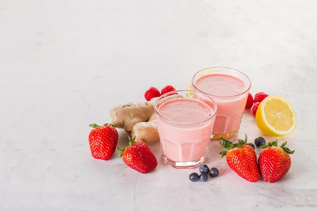 Twee rode smoothies met aardbeien, gember en citroen