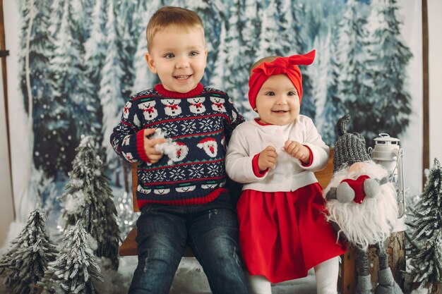 Twee schattige kinderen zitten in een kerstversiering