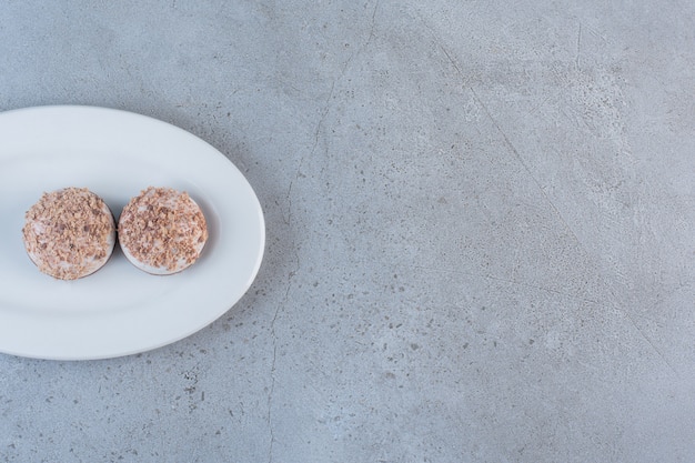 Twee smakelijke truffelballen op een witte plaat geplaatst.