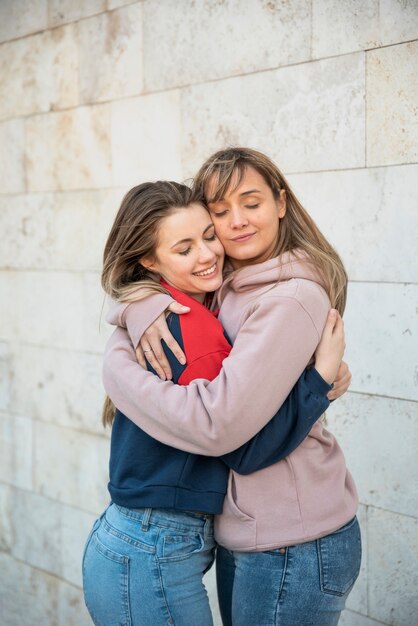 Twee smiley jonge vrouwen knuffelen