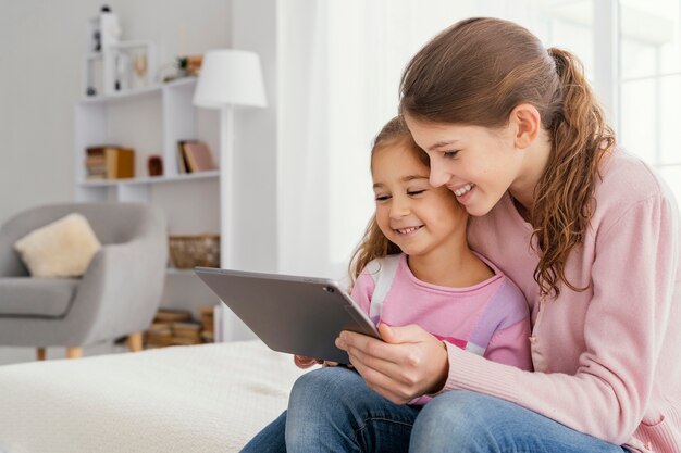 Twee smileyzusjes samen thuis met behulp van tablet